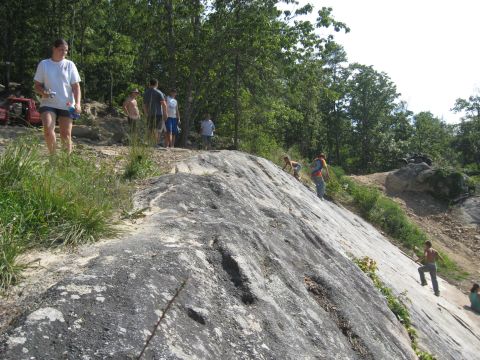 1978 Ford Bronco - A red 1978 Ford Bronco is parked on a rocky, wooded hillside with several people around.