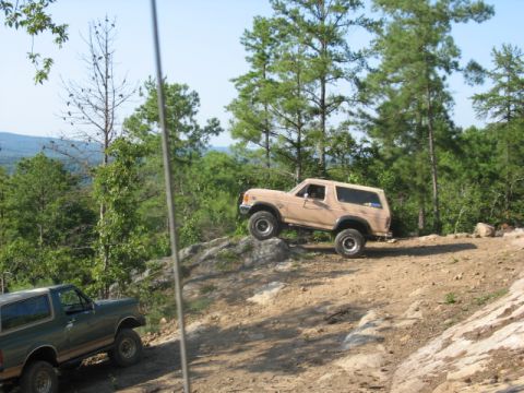 1978 Ford Bronco - Two Ford Broncos navigate a challenging off-road trail with steep inclines and rocky obstacles.