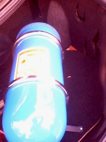 1999 Ford Taurus - Blue tank with yellow label visible inside a car's trunk area.