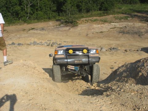 Tan off-road SUV with smiley face lights and 'MULE' plate, front view