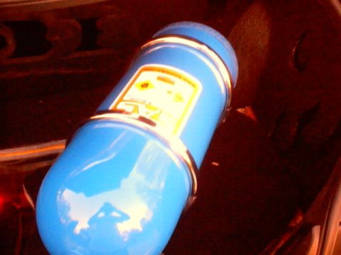 1999 Ford Taurus - A blue nitrous oxide tank is visible, mounted with metal straps. A yellow label with text is on its side.
