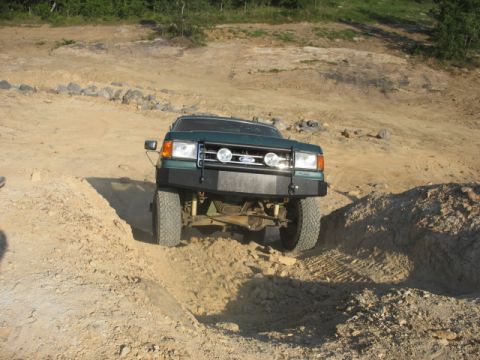 Green 1987 Ford F-Series truck with aftermarket bumper off-roading