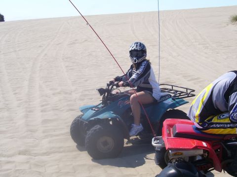1991 Ford Bronco - Two ATVs are parked on a sandy dune under a clear sky.