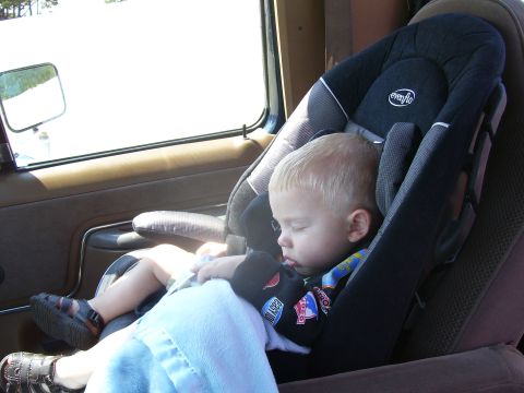1991 Ford Bronco - A child sleeps in a car seat, viewed from the interior of a vehicle.