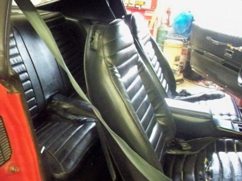 1974 Pontiac Firebird - The interior of a 1974 Pontiac Firebird features ribbed black vinyl seats and light green seatbelts.