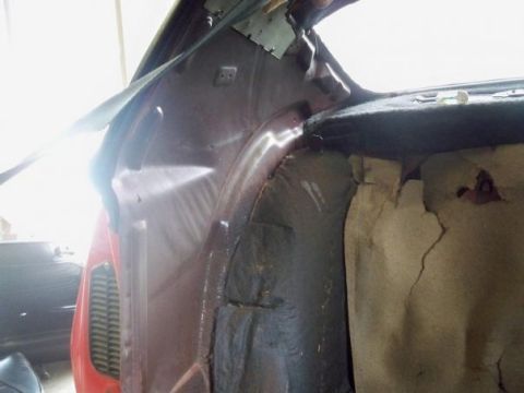 1974 Pontiac Firebird - The interior of a car's rear quarter panel shows exposed insulation and metal structure.