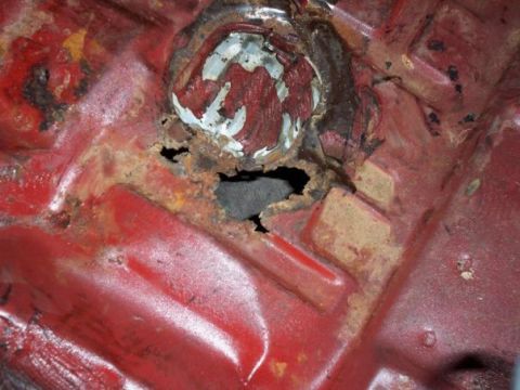 1974 Pontiac Firebird - Significant rust damage is visible on the vehicle's floor pan, with a large hole exposing the undercarriage.
