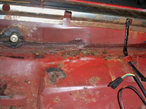 1974 Pontiac Firebird - Rusted interior floor pan shows signs of significant corrosion and exposed wiring harness.
