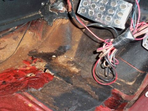1974 Pontiac Firebird - The interior floor pan shows significant rust damage and exposed wiring near the pedals.