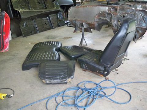 1974 Pontiac Firebird - Interior car parts and a partially restored chassis are visible in this workshop setting.