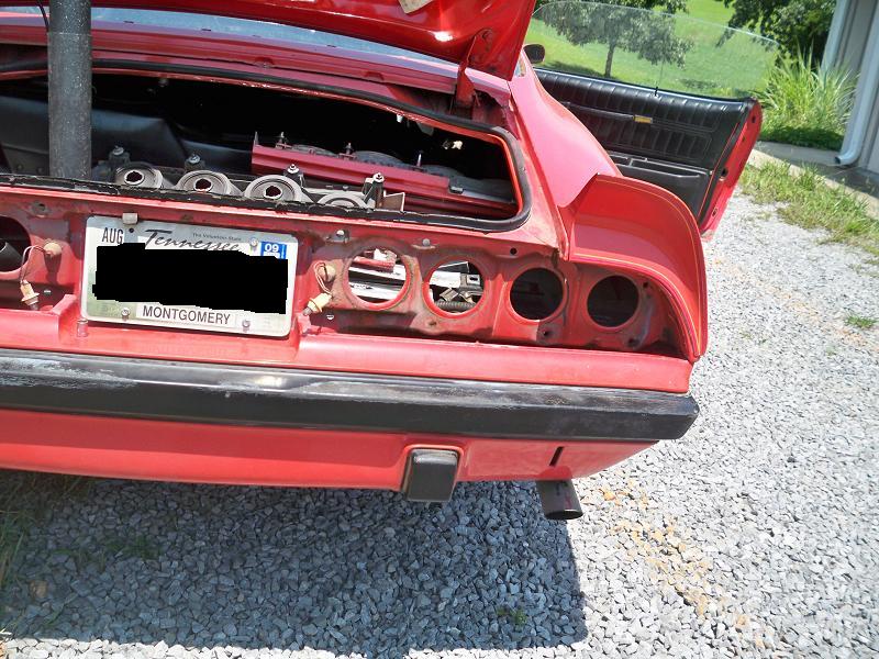 Red 1974 Pontiac Firebird rear end with trunk open, taillights removed, and Tennessee license plate