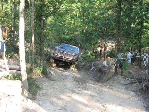 1978 Ford Bronco - A 1978 Ford Bronco navigates a challenging muddy incline during an off-road event.