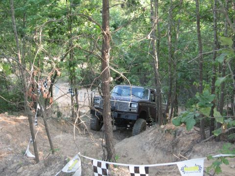 1978 Ford Bronco - This Ford Bronco is navigating a wooded off-road course marked with checkered flags.