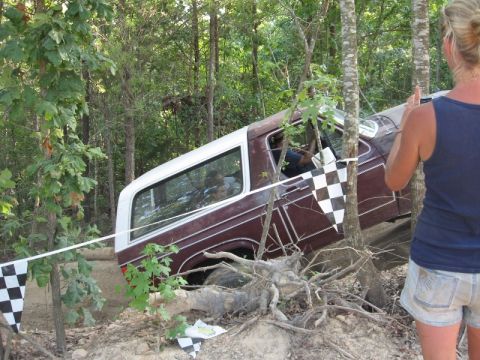 1978 Ford Bronco - A 1978 Ford Bronco is seen maneuvering through an off-road obstacle course, marked by checkered flags.