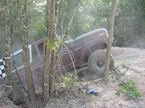 1978 Ford Bronco - Ford Bronco navigating an off-road trail, tilted on a dirt incline.