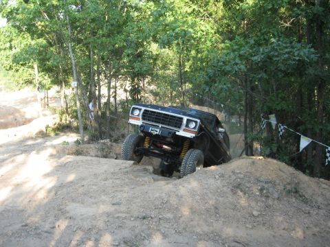 1978 Ford Bronco - A black Ford Bronco tackles a challenging dirt track during an off-road event.
