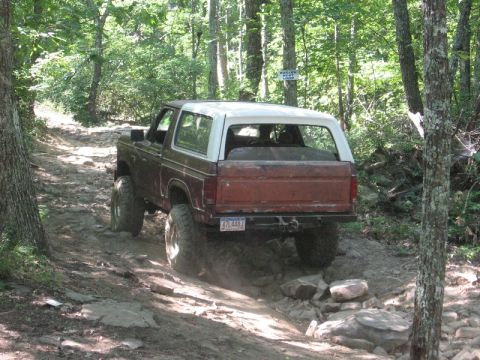 1978 Ford Bronco - This 1978 Ford Bronco navigates a challenging off-road path through a wooded area.