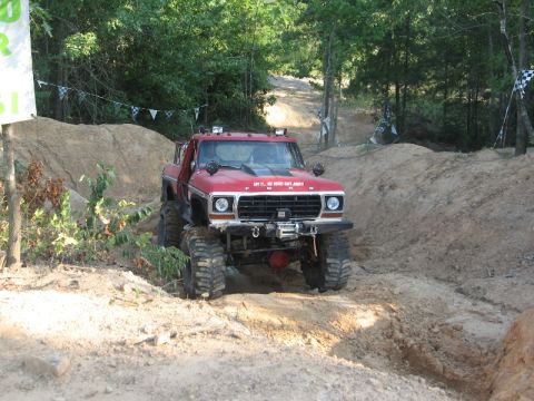 1978 Ford Bronco - This modified Ford truck navigates a challenging off-road course with steep inclines and sandy terrain.