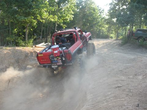 1978 Ford Bronco - Modified 1978 Ford Bronco navigates a dusty off-road trail, with another vehicle in the background.