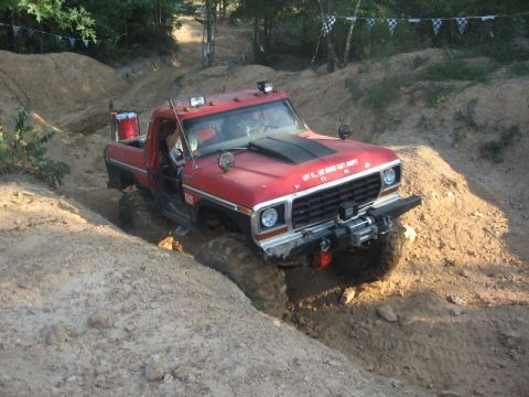 1978 Ford Bronco - This red truck navigates a challenging off-road course, its capabilities.