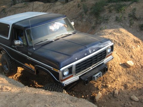 1978 Ford Bronco - A 1978 Ford Bronco navigates a dirt trail with steep inclines.