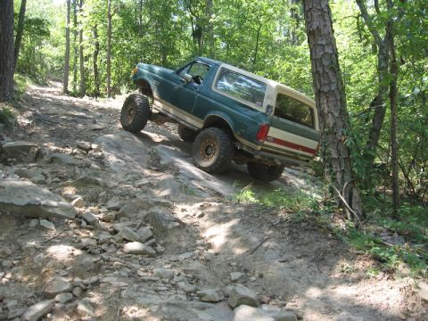 1978 Ford Bronco - This SUV is navigating a challenging off-road course with steep inclines and large rocks.
