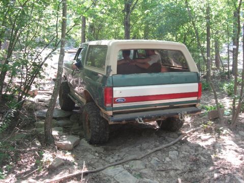 1978 Ford Bronco - This SUV navigates a challenging, rocky off-road path through a wooded area.