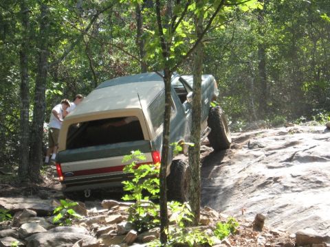 1978 Ford Bronco - This vehicle is navigating a difficult, rocky trail in a wooded area.