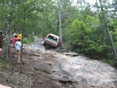 1978 Ford Bronco - A 1978 Ford Bronco navigates a challenging rocky terrain with onlookers present.