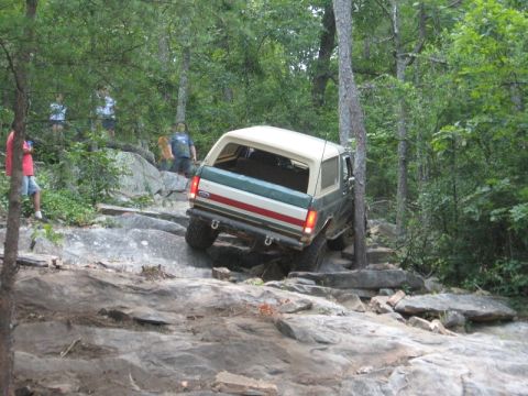 1978 Ford Bronco - This Ford Bronco is navigating a rocky, wooded trail, its off-road capabilities.