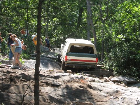 1978 Ford Bronco - A white Ford Bronco navigates a rocky trail with several onlookers.