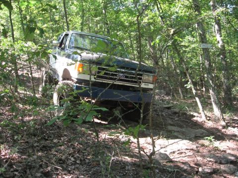 1978 Ford Bronco - A Ford Bronco navigates a rocky, wooded path.