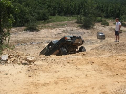 1978 Ford Bronco - An off-road vehicle is stuck in a dirt pit while another SUV waits in the background.