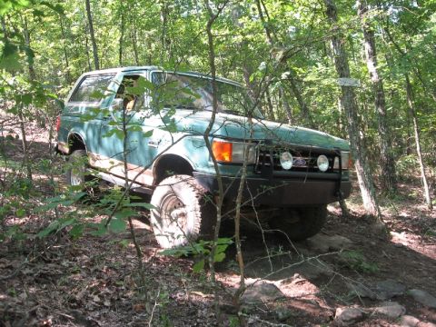1978 Ford Bronco - Ford Bronco navigates a rocky, wooded path.