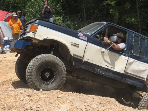 1978 Ford Bronco - A modified truck navigates a challenging off-road course with spectators watching.