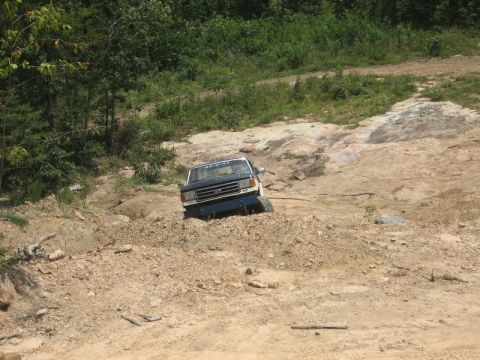 1978 Ford Bronco - This Ford F-Series truck, likely from the early 1980s, is shown tackling a challenging off-road course.