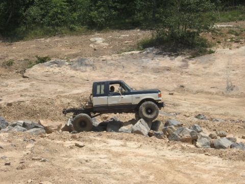 1978 Ford Bronco - This modified pickup truck is navigating a rocky obstacle course on a sunny day.