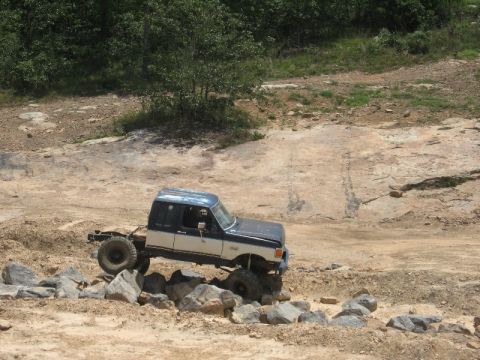 1978 Ford Bronco - A modified pickup truck with a custom rear frame tackles a challenging off-road course.