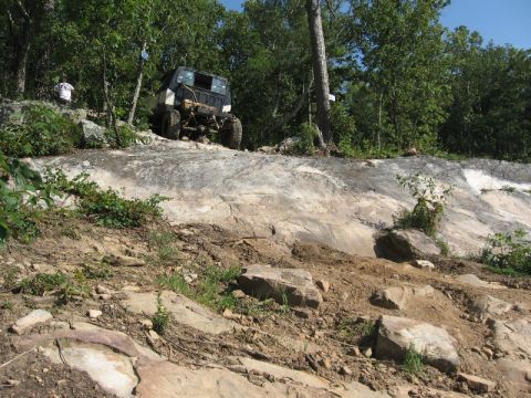 1978 Ford Bronco - A modified off-road vehicle navigates a challenging rocky terrain.