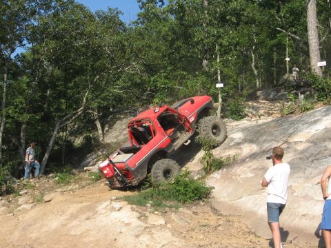 1978 Ford Bronco - Modified 1978 Ford Bronco tackling a challenging rocky trail with spectators observing the climb.