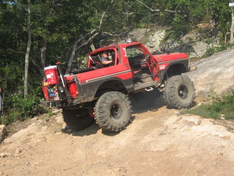 1978 Ford Bronco - Modified 1978 Ford Bronco tackling a challenging off-road trail with steep rocks.