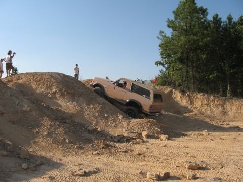 1978 Ford Bronco - 1978 Ford Bronco navigating a challenging off-road course on a sunny day.