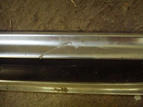 1995 Ford Bronco - Close-up of damaged chrome trim, showing a crack and some white residue.
