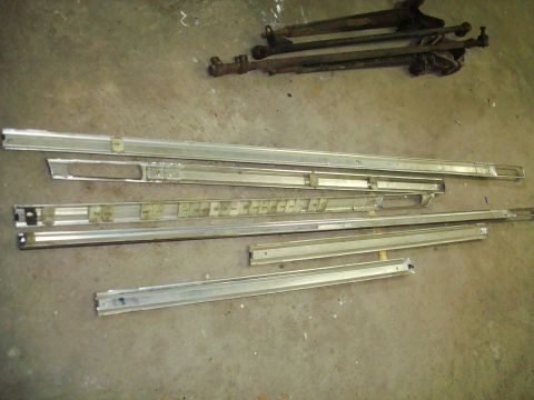 1995 Ford Bronco - Various chrome trim pieces and suspension components are laid out on a concrete surface.