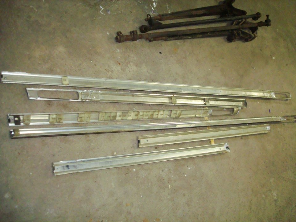Chrome trim pieces and suspension parts on concrete floor