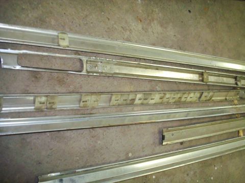1995 Ford Bronco - Metal trim pieces with clips are shown laid out on a concrete surface.
