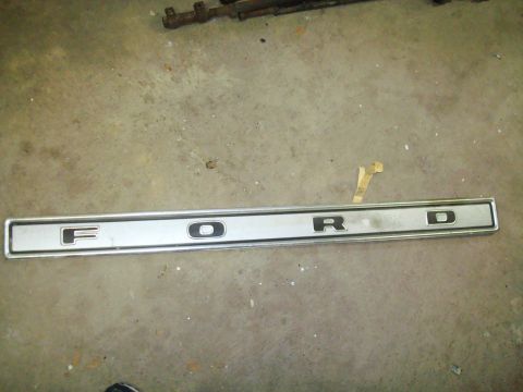 1995 Ford Bronco - A silver trim piece with the letters F-O-R-D is shown on a concrete surface.