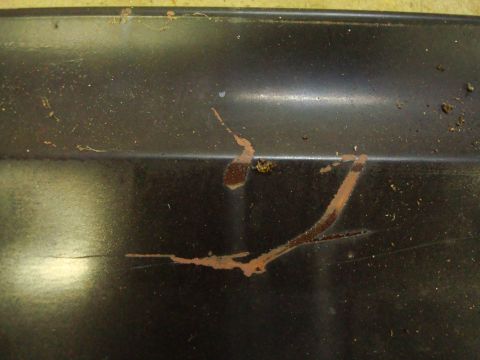 1995 Ford Bronco - Close-up of rust streaks on a dark, textured surface, with a website logo visible at the bottom right.