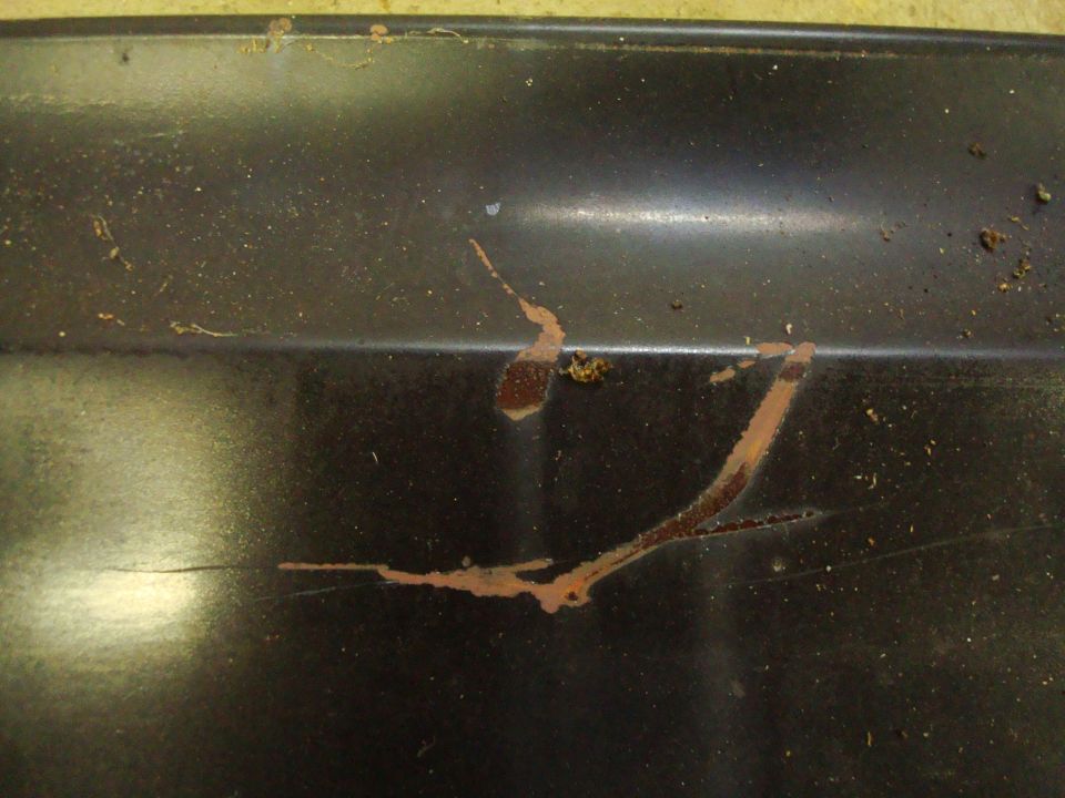 rust streaks on a dark surface, possibly a car panel. Supermotors.net logo in corner