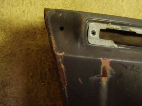 1995 Ford Bronco - Close-up of a damaged car fender section with visible rust and a mounting point.